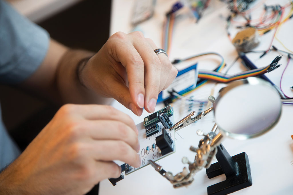 Hands wiring a hardware device