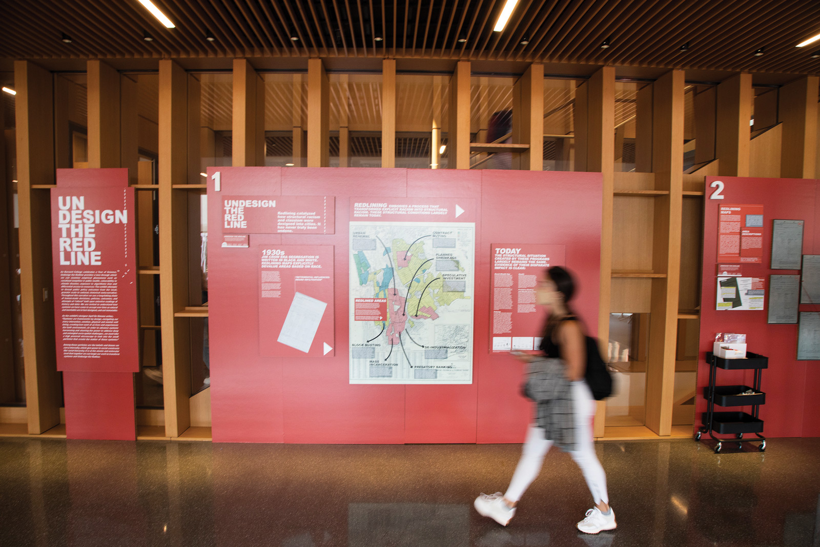 A student walks passed the "Undesign the Redline" display