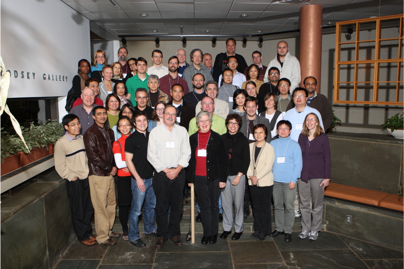 About 30 researchers stand together on a set of stairs looking at the camera