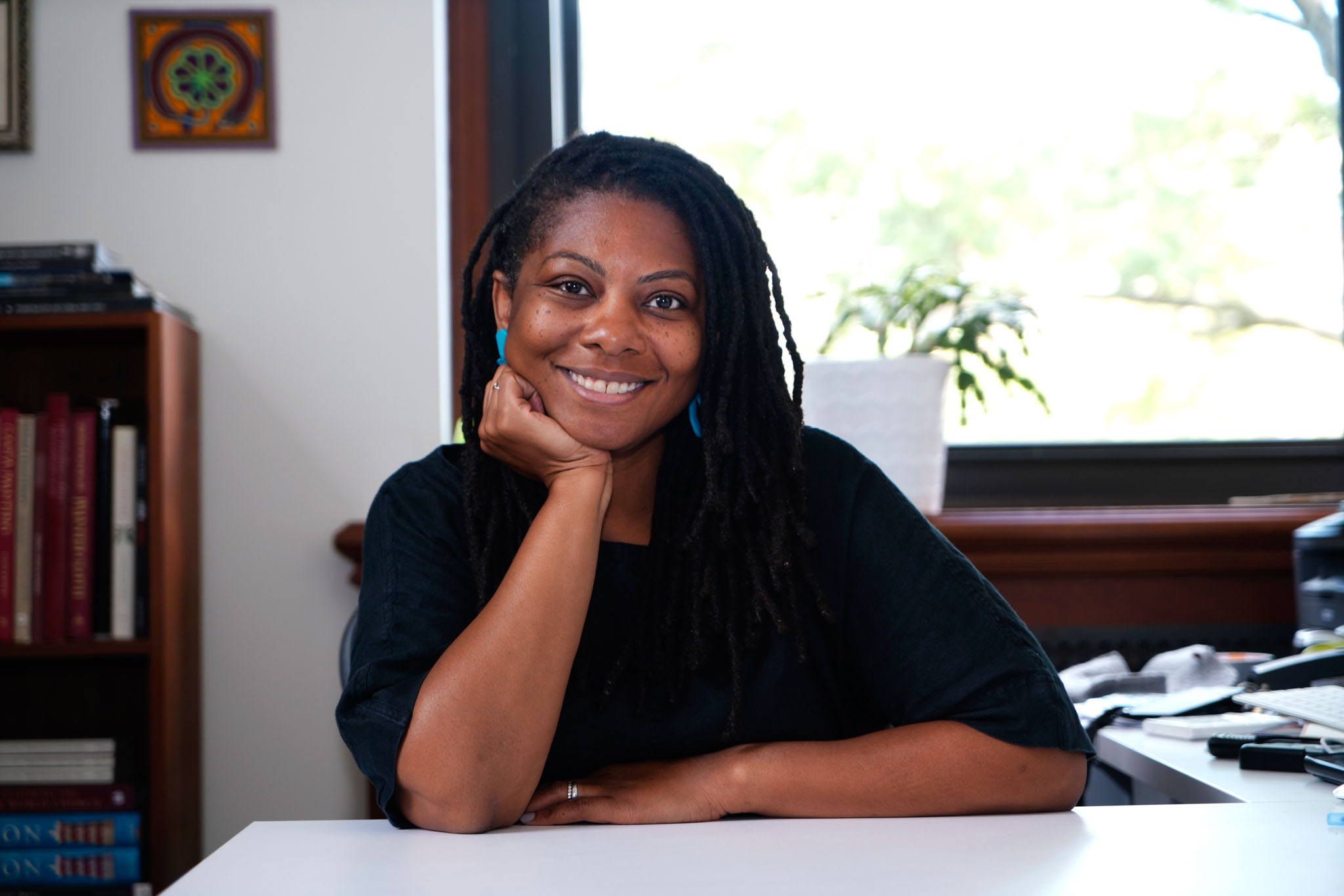 headshot of Tamara J Walker. She is sitting at a desk with her right hand propping her chin up.