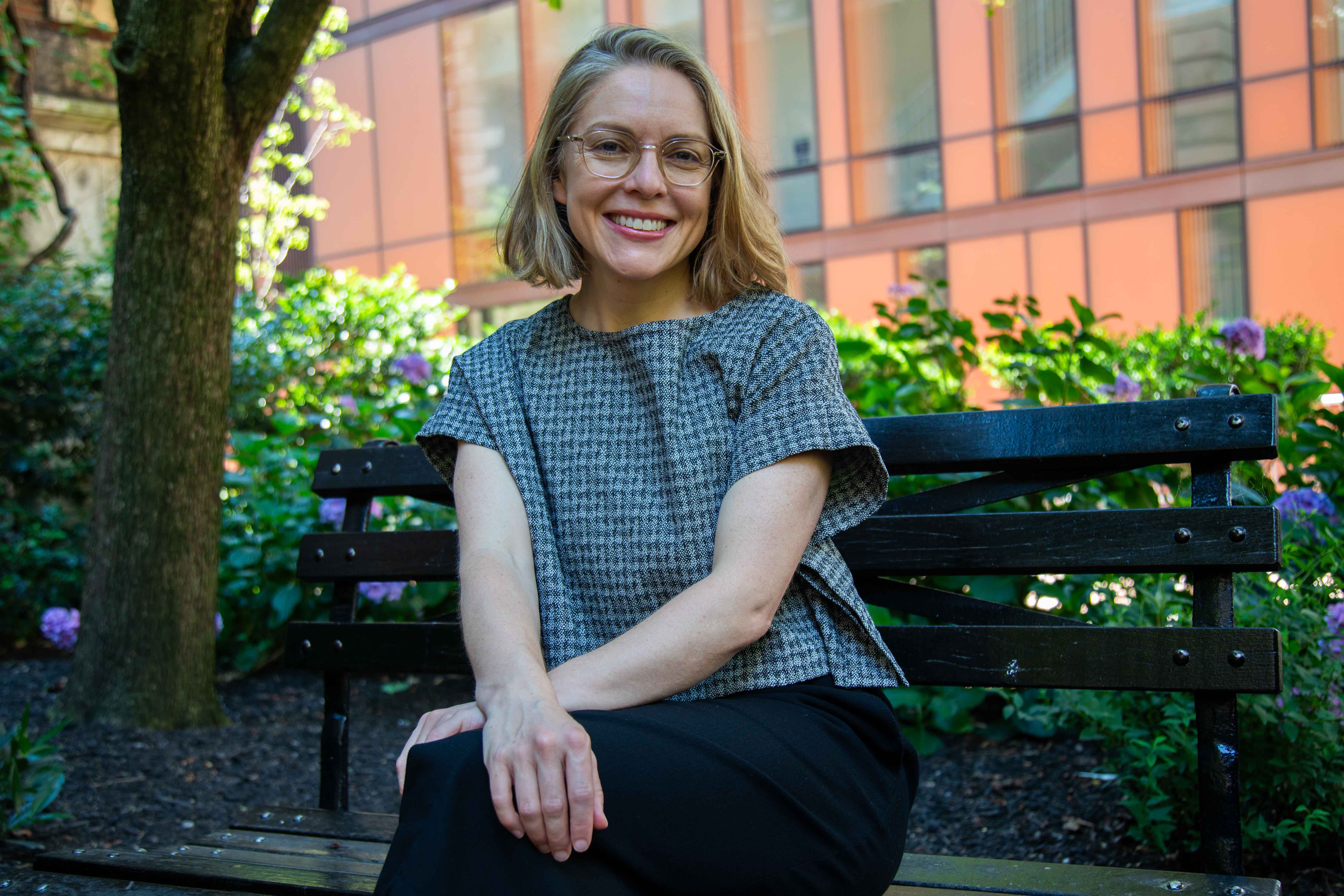 Serena Longley headshot. she is sitting on a bench