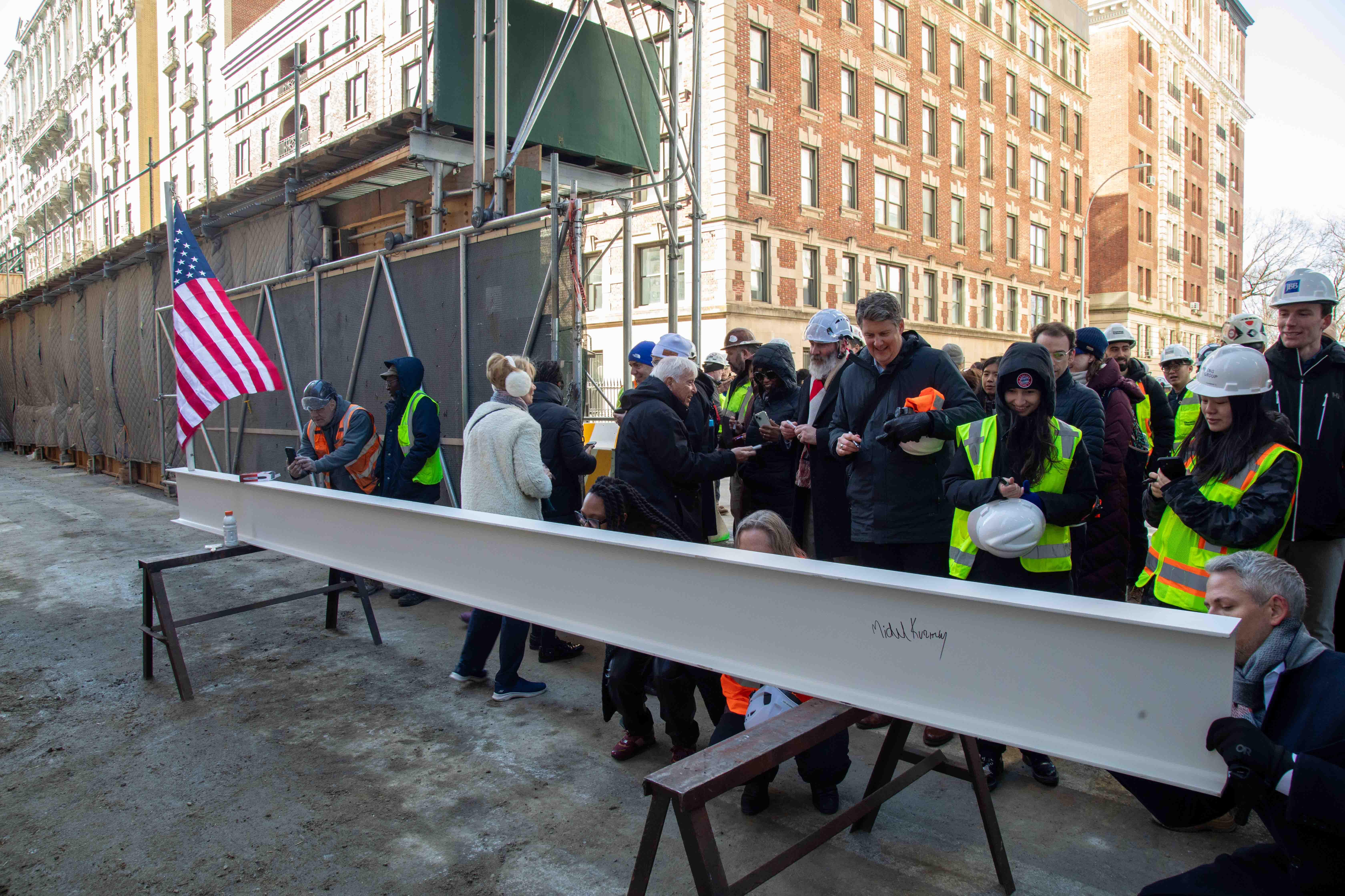 Members of the construction team sign the metal beam