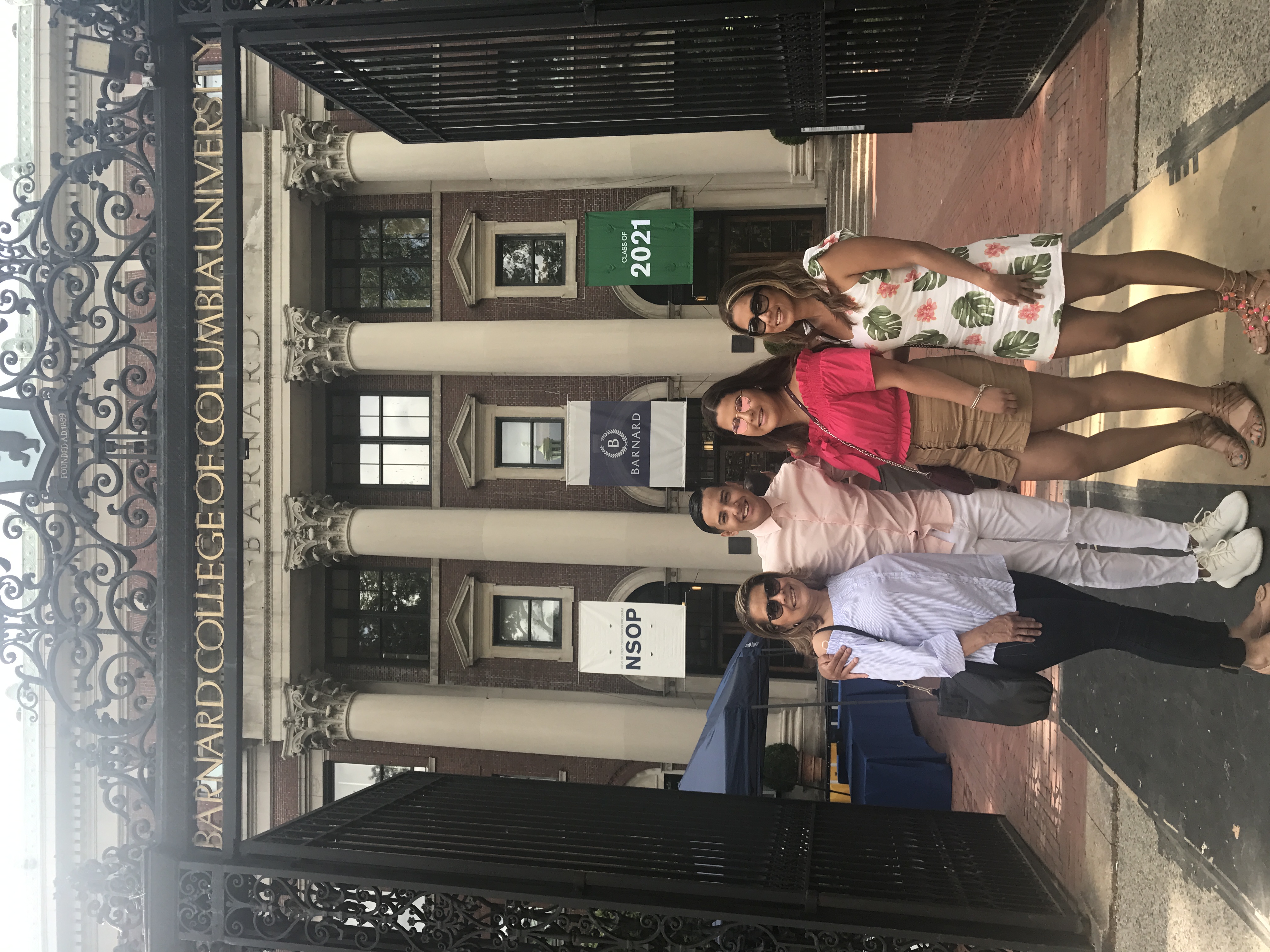 Burgos standing with three family members in front of the Barnard gates