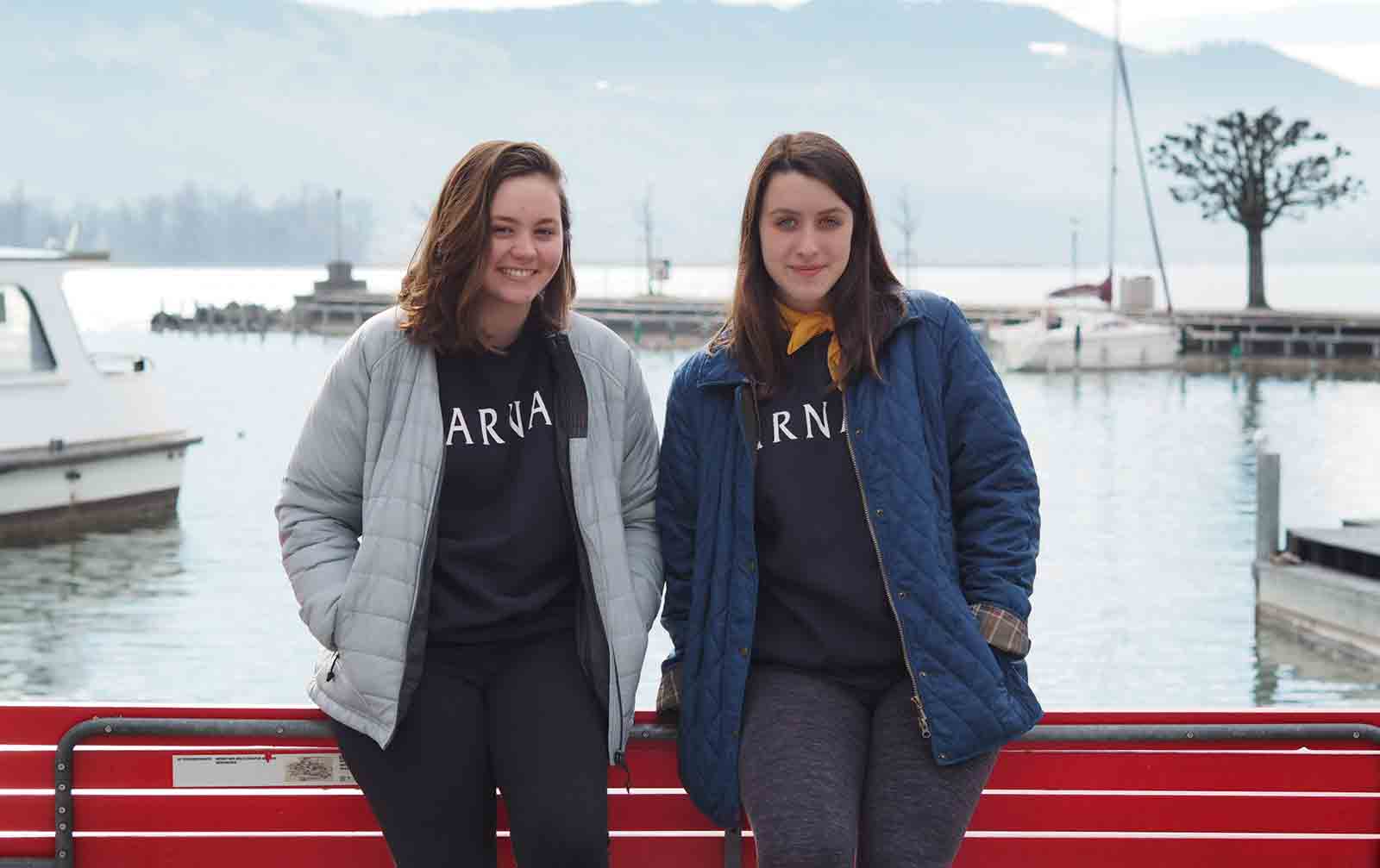 Two young women standing together by the river