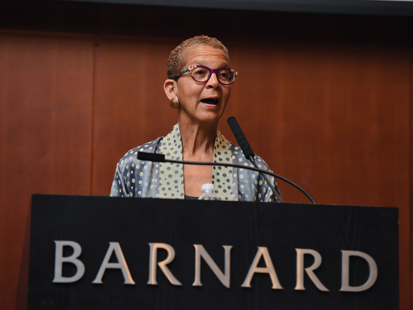 woman speaking into microphone at podium