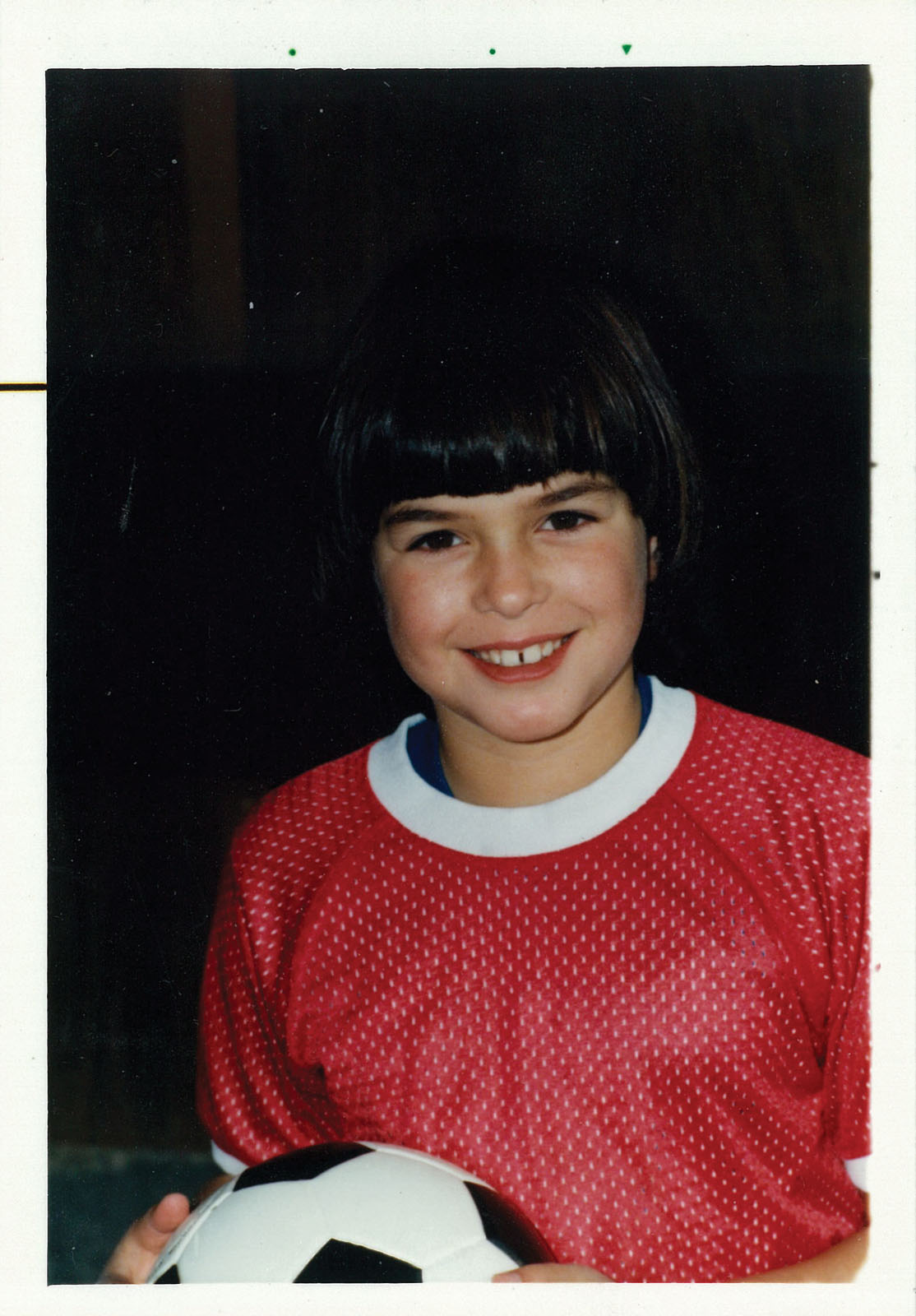 Young girl holding a soccer ball