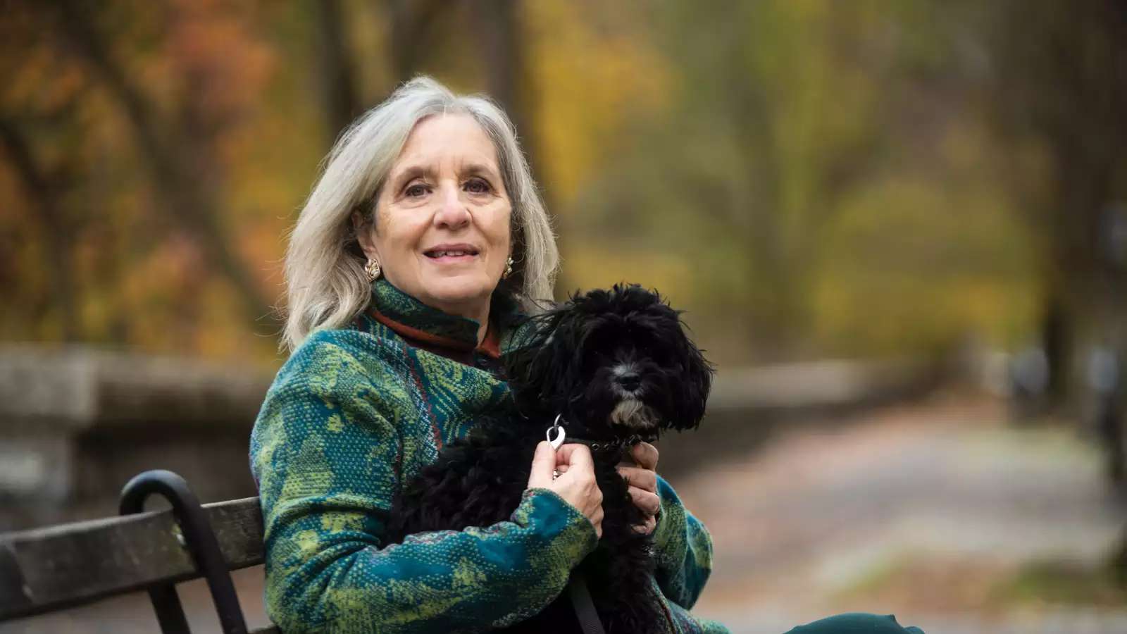 Mary Gordon photo on a park bench with her dog