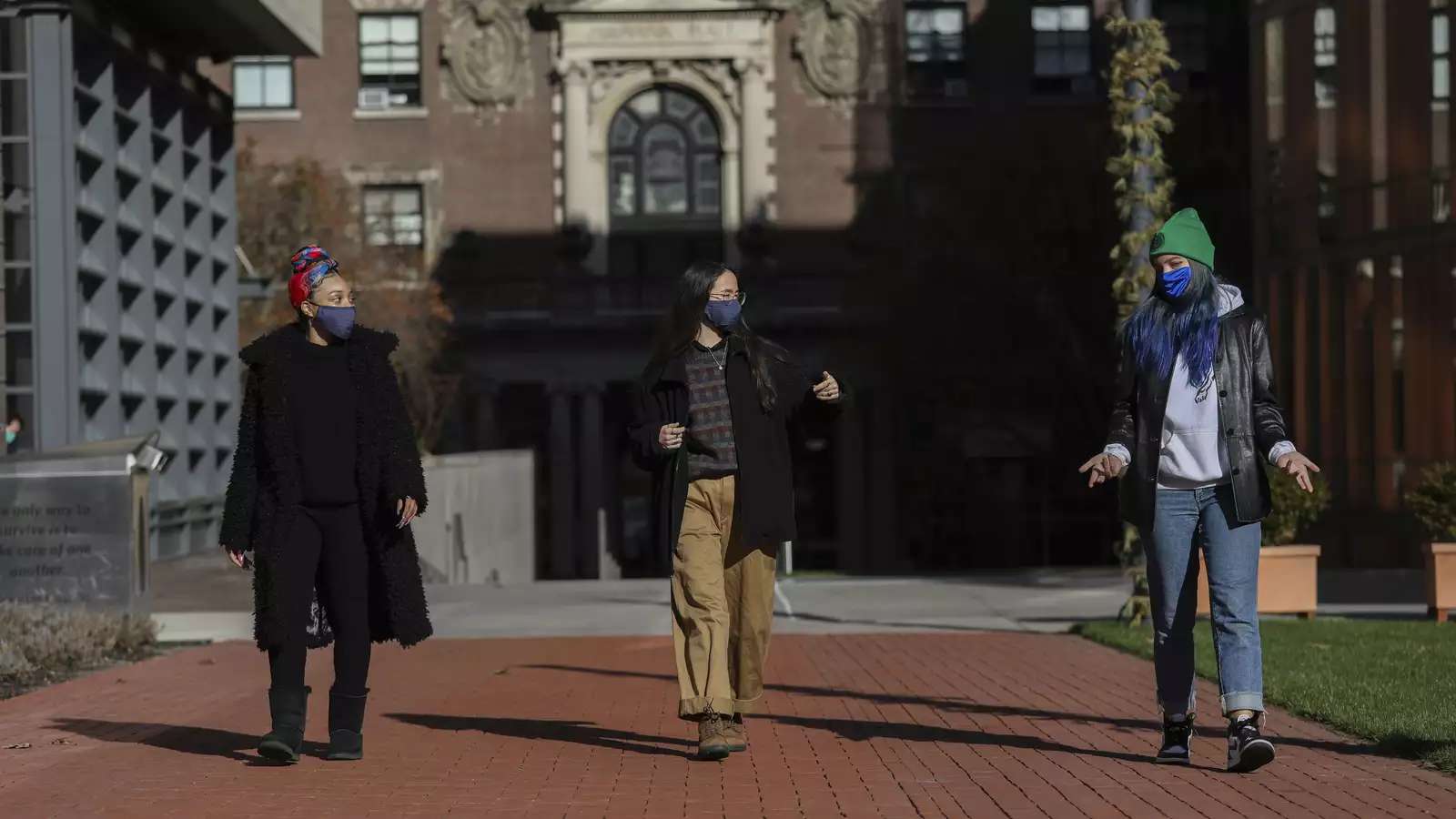 Three Barnard Health Ambassadors walking in front of the Milstein Library on campus.