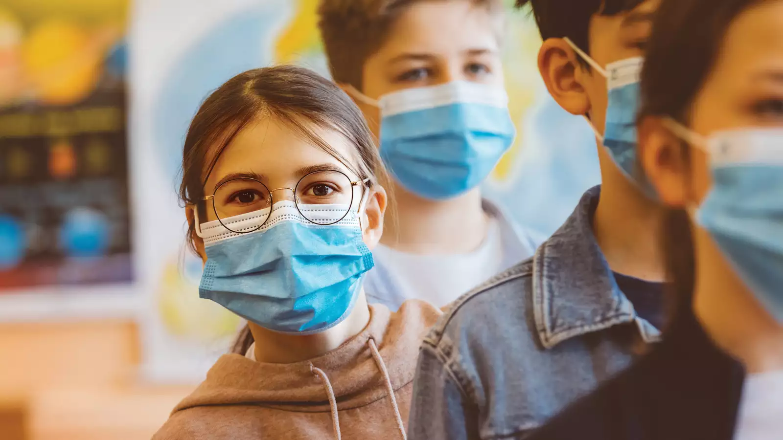 Children waiting in line with a mask