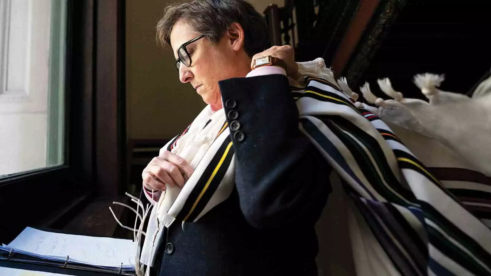 Rabbi Kleinbaum prepares for temple throwing tallit prayer shaw over shoulder