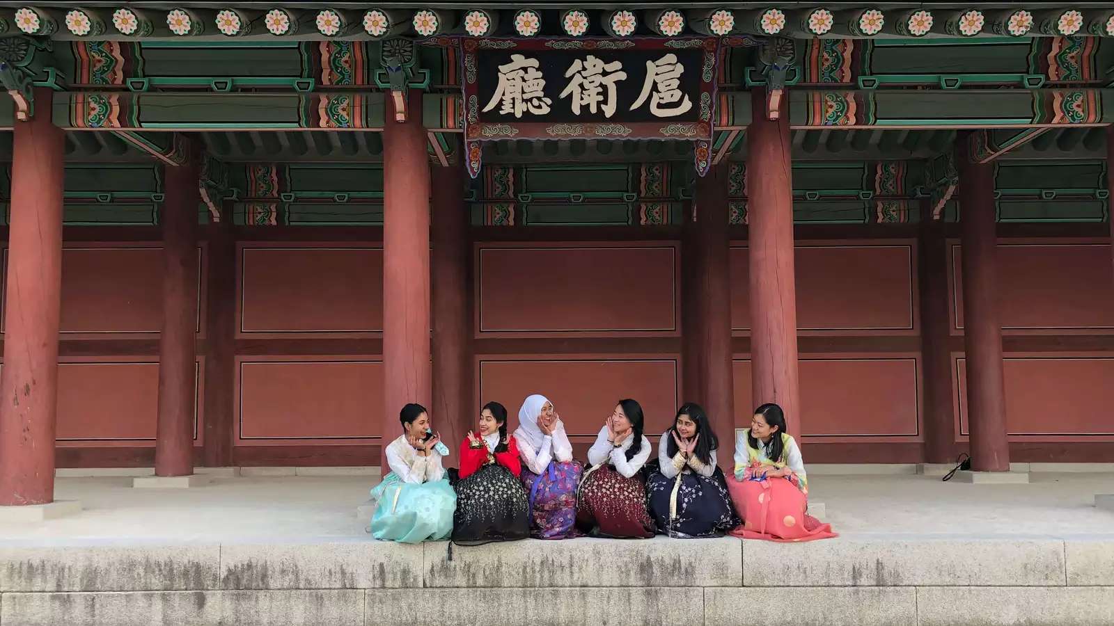 several women seated in front of a building in China