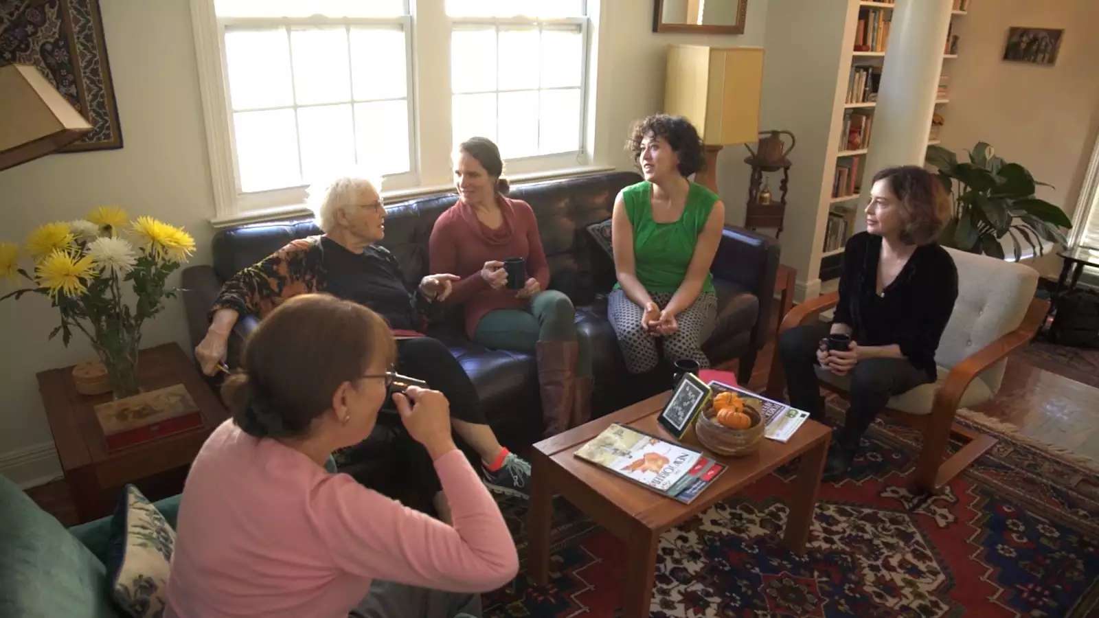 Several women of different ages seated in a living room