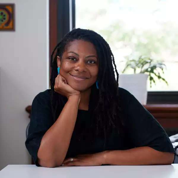 Tamara Walker smiling at desk in black top