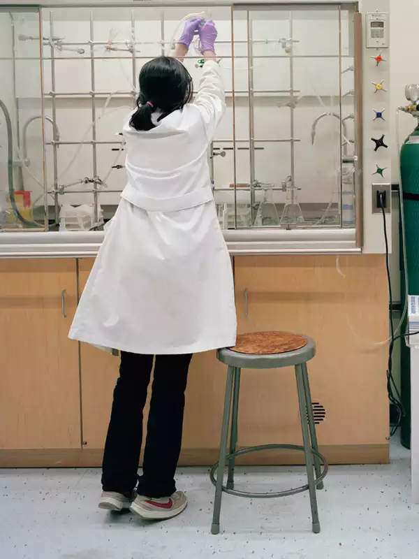 student in lab coat in the lab