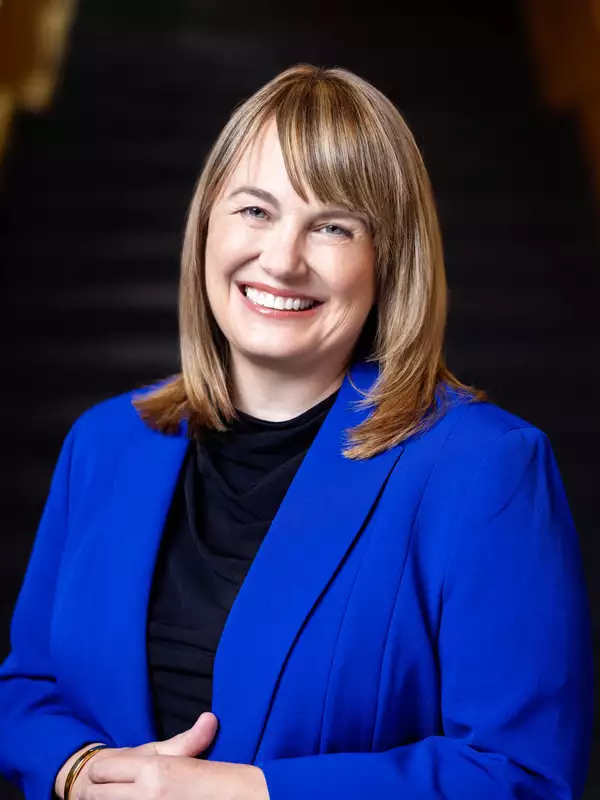 Laura Rosenbury wearing a bright blue blazer, smiling