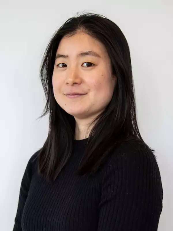 White background, woman smiling with black hair, black shirt