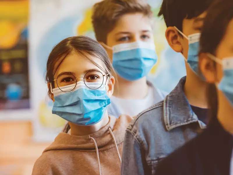 Children waiting in line with a mask