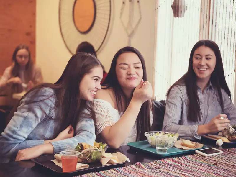 3 young women enjoying lunch in the dining hall