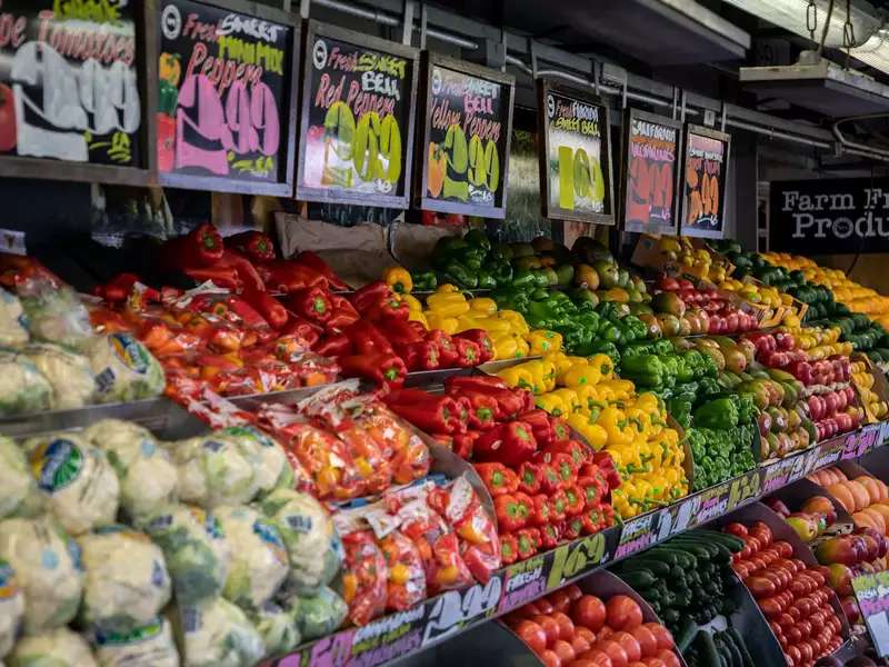 colorful vegetables in bins with price signs above