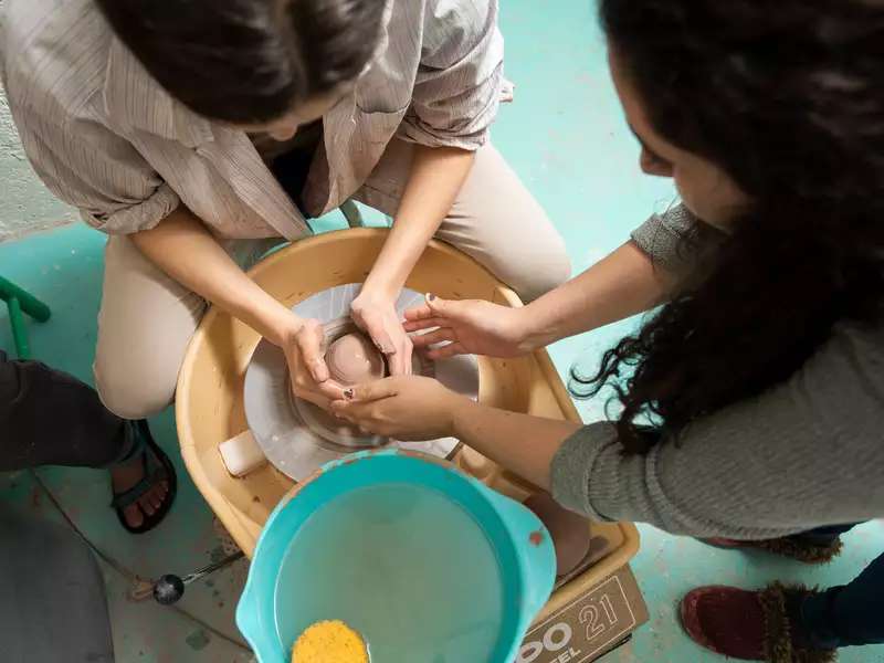 2 students working at a pottery wheel