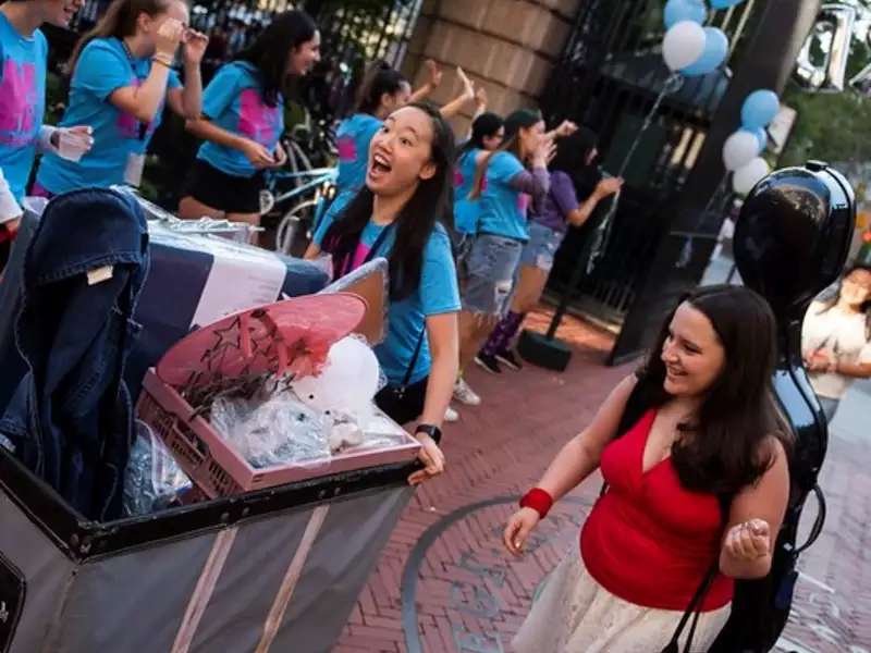 Happy student pushing a cart with her stuff on move-in day