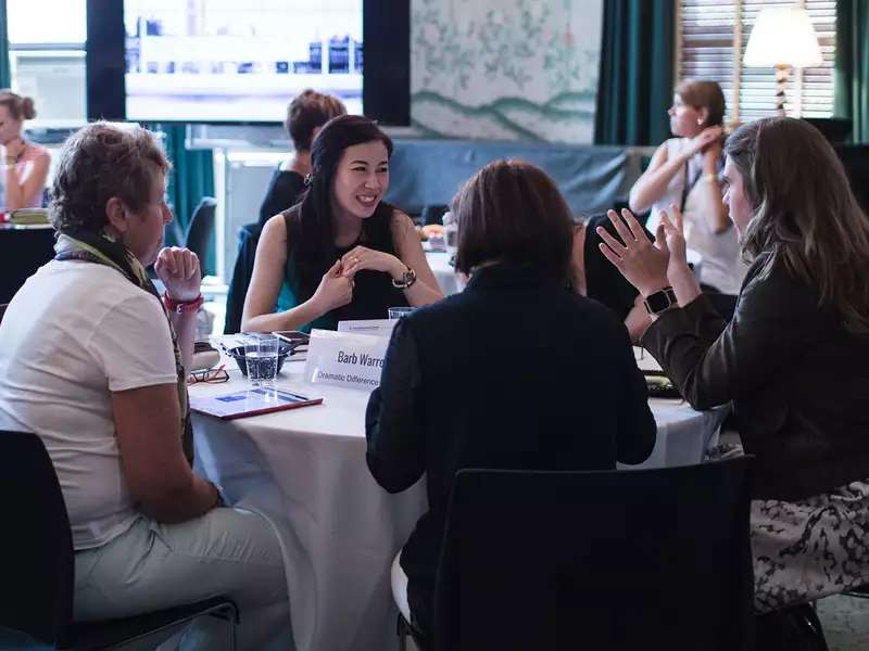 4 women sitting together at a table over lunch