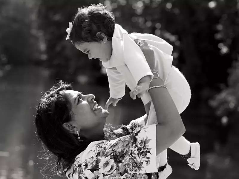 Woman holding her baby up over her head