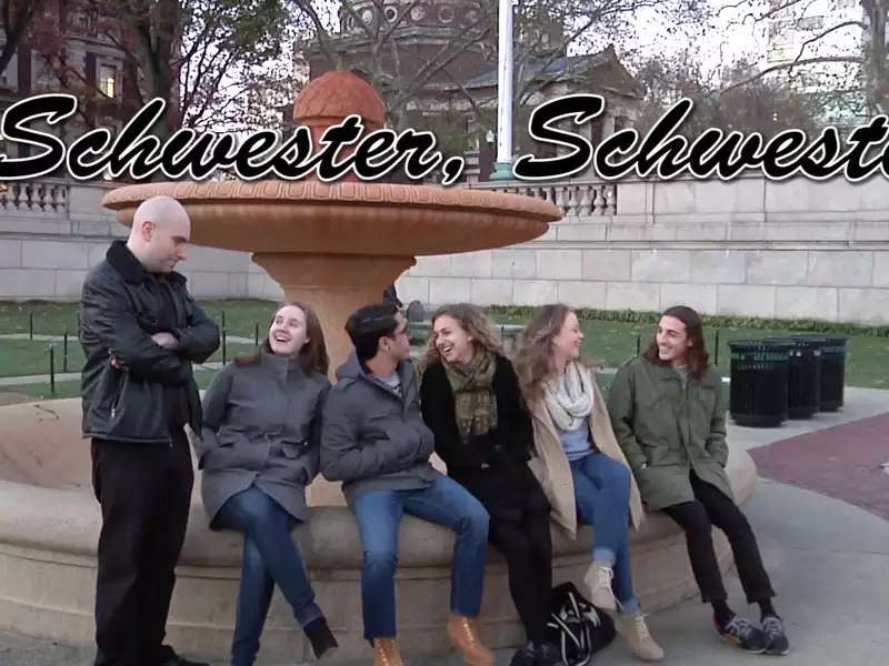 Several people sitting on the edge of an outdoor fountain